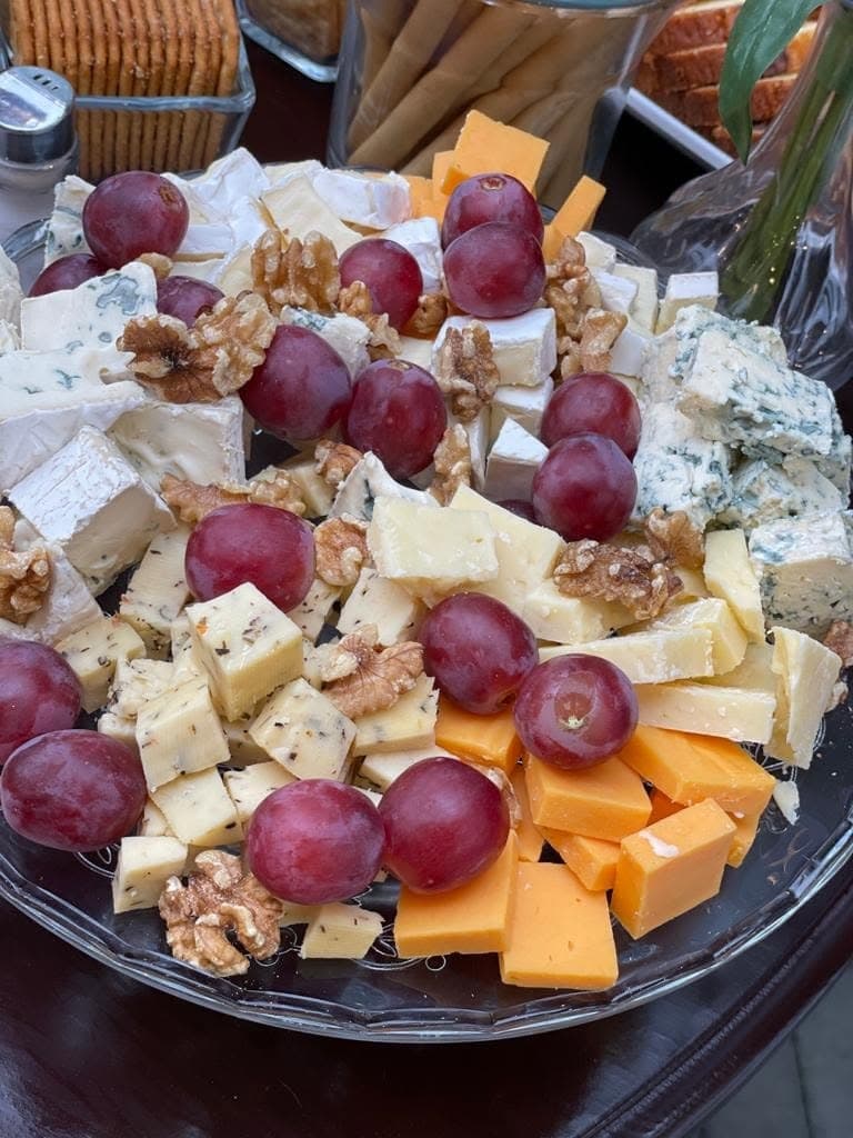A platter of cheeses, grapes and walnuts