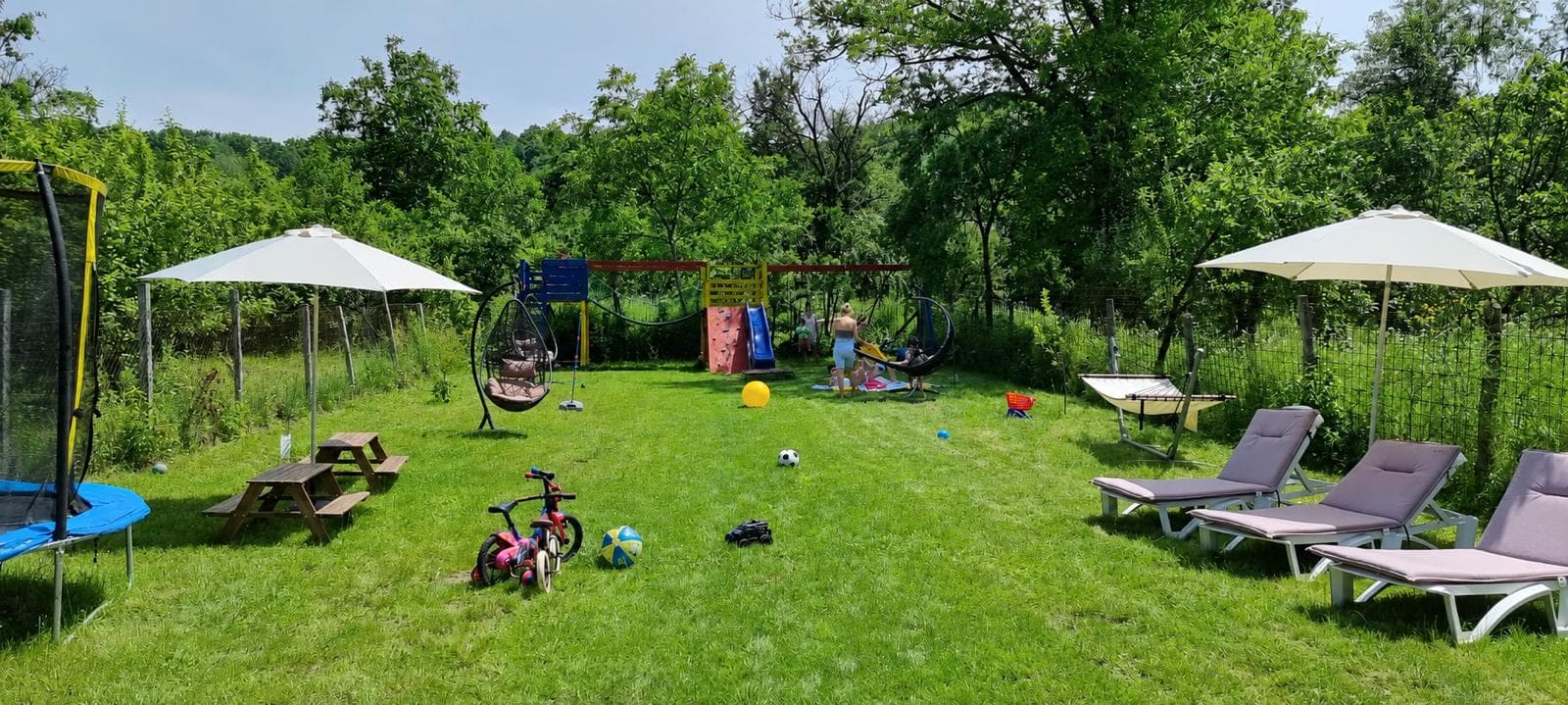 The garden with the children's playground, trampoline and sun loungers