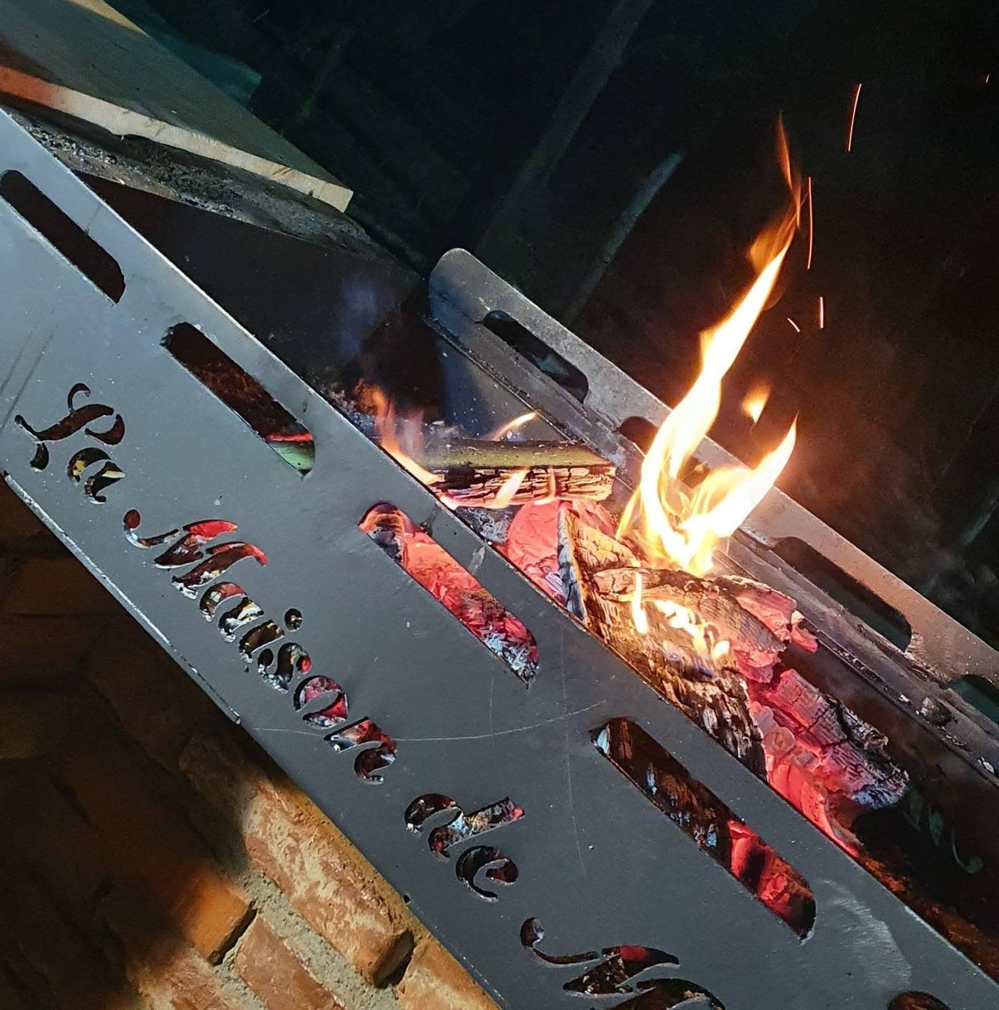 Embers and flame in the grill, its plate engraved La Maison de Moise